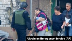 Az emberek szeptember 29-én kiürítették romos otthonukat az irányított bombákkal végrehajtott orosz támadás után