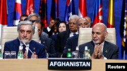 FILE: Afghan President Ashraf Ghani (R) and Afghanistan's Chief Executive Abdullah Abdullah applaud during a session at the NATO Summit in Warsaw in July 2016. 