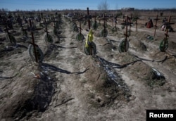 Varre të njerëzve të vrarë në Buça, pranë Kievit.