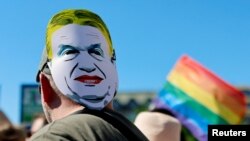 Egy résztvevő Orbán Viktor miniszterelnököt ábrázoló maszkot visel a fején a Budapest Pride Felvonuláson, 2025. június 28-án