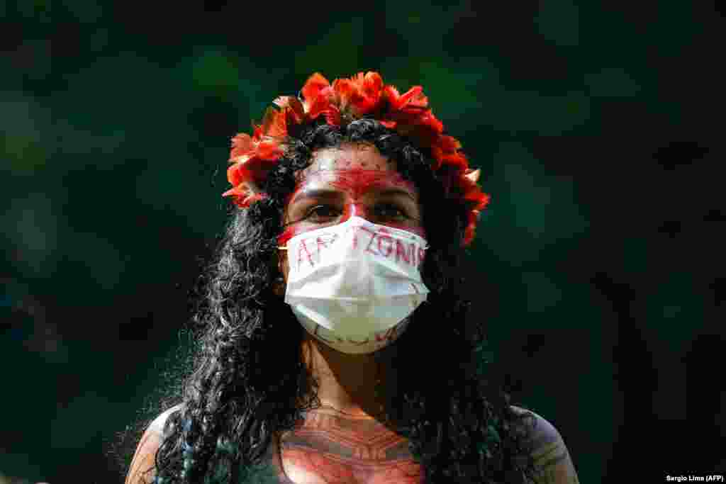 Őslakos nő tüntet Bolsonaro tervezete ellen, amely legalizálná földjeiken az aranybányászatot. A brazil elnök egy beszédében azt mondta, az őslakos területek akadályozhatják az ország fejlődését