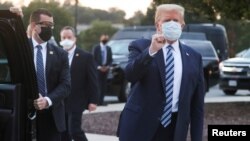Donald Trump sa podignutom stisnutom pesnicom pozdravlja pristalice nakon izlaska iz bolnice 5 oktobra 2020.