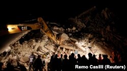 Рятувальники працюють уночі на місці руйнувань у місті Аматріче