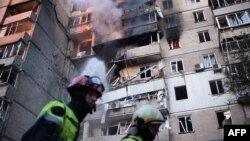 Пожарникари работат на тешко оштетена станбена зграда по руските напади со беспилотни летала и ракети во Киев на 7 септември.