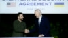 Președintele ucrainean Volodimir Zelenski (stânga) și președintele american Joe Biden semnează un acord bilateral de securitate, 13 iunie 2024, la Summitul G7 din Italia.