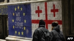 Pietoni trecând pe lângă un apel la apropierea de UE la Tbilisi, pe 11 decembrie 2024.