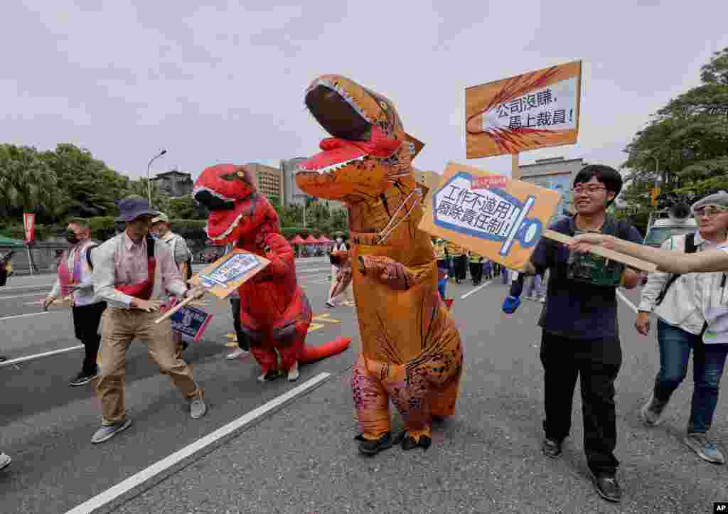 Punëtorë tajvanezë, të veshur si dinosaurë, duke protestuar në Tajpei.