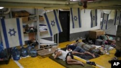 Israelieni într-un adăpost improvizat într-un garaj subteran, în zorii zilei de marți.