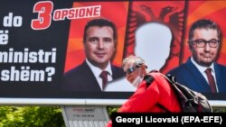 Një burrë kalon pranë një panoje të vendosur nga BDI-ja, parti e cila po kërkon që Maqedonia e Veriut të ketë kryeministrin e parë shqiptar. 