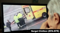 Алексея Навального загружают в машину скорой помощи в аэропорту Омска, 20 августа 2020 года