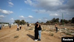 Двама души се прегръщат на погребението на Еден Гуез, убита по време на музикалния фестивал край Ашкелон, Южен Израел, 10 октомври.