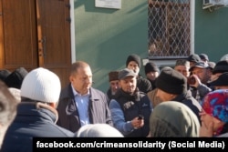 Вице-премьер российского правительства Крыма Альберт Куршутов общается с крымскотатарскими активистами, пришедшими узнать о своих соотечественницах, задержанных ФСБ по обвинению в терроризме, октябрь 2025 года