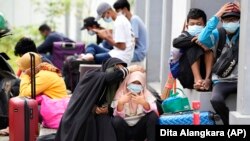Koronavírussal fertőzöttek várakoznak, hogy kórházba kerüljenek az indonéziai Jakartában 2021. június 18-án. A fertőzöttek számának megugrását részben a koronavírus új variánsainak, például a delta-változatnak tulajdonítják