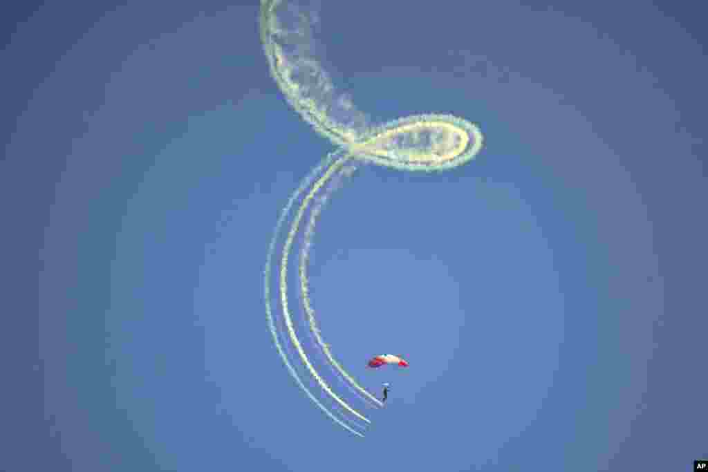 Un parașutist cu steagul canadian, deasupra Plajei Juno, lângă&nbsp;Courseulles-sur-Mer, Franța, pe 6 iunie 2024. Canada a fost - după Marea Britanie și SUA - țara care a contribuit cel mai mult cu militari la operațiune. Au mai fost implicate contingente din alte țări, ca Polonia sau Cehoslovacia, care luptau în exil, departe de țările lor ocupate de hitleriști.&nbsp;