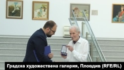 Зам.-кметът по културата на Пловдив Пламен Панов поднася почетния плакет на града на художника Емил Стойчев, 18 юни 2025 г.