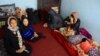 An Afghan family sits in an International Organization for Migration transit center in the western Herat Province after returning from Iran on August 2. 