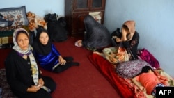 An Afghan family sits in an International Organization for Migration transit center in the western Herat Province after returning from Iran on August 2. 