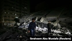 Palestinski policajac pored porušene zgrade u Gazi 11. maja 2021. godine