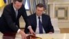 Виктор Янукович подписывает соглашение, которое он не хотел бы подписывать