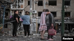 Banorët vëzhgojnë dëmet në një ndërtesë banimi në Zaporizhja, pas një sulmi ajror rus më 30 gusht.