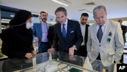 Directorul general IAEA, Rafael Mariano Grossi (centru) vizitând o expoziție de „realizări nucleare” iraniene la Teheran, pe 17 aprilie 2025.