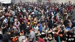 Palestinieni la un punct de distribuire a ajutoarelor, la tabăra de refugiați Nuseirat, din centrul Fâșiei Gaza, pe 19 iulie 2025.