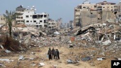 Палестинци минават покрай сграда, разрушена при израелската бомбардировка на Ивицата Газа в град Газа в сряда, 3 януари 2024 г. 