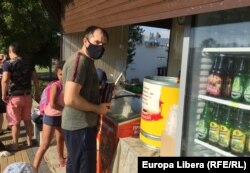 Moldova -- Tiraspol, tânăr cu mască în fața unei tarabe stradale, încghețată, pop corn, cafea, afaceri mici, afacere mica, regiunea transnistreană, odihna, covid-19, epidemie, pandemie, Transnistria, separatist, 12Jul2020