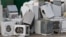 Old electrical appliances in container of recycling center.