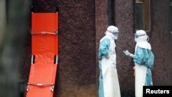 Zdravstveni radnici u zaštitnoj odjeći iza barijera koje obilježavaju izolaciju gdje se liječe žrtve smrtonosnog virusa Marburg u gradu Uige na sjeveru Angole, fotoarhiv