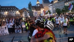 Studenti biciklisti u zagrljaju nakon što su došli na odredište - u Strazbur, Francuska, 15. aprila 2025. 