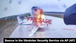 Lángokban álló orosz katonai repülőgép egy ukrán támadó drónról készült videófelvételen a Belaja légitámaszponton, az orosz-mongol határ közelében.