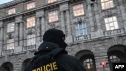 Ходими полиси Чехия ба ҳангоми ҳодисаи тирандозӣ дар донишгоҳи Карлови шаҳри Прага дар декабри соли 2023 дар назди ин муассиса қарор дорад 