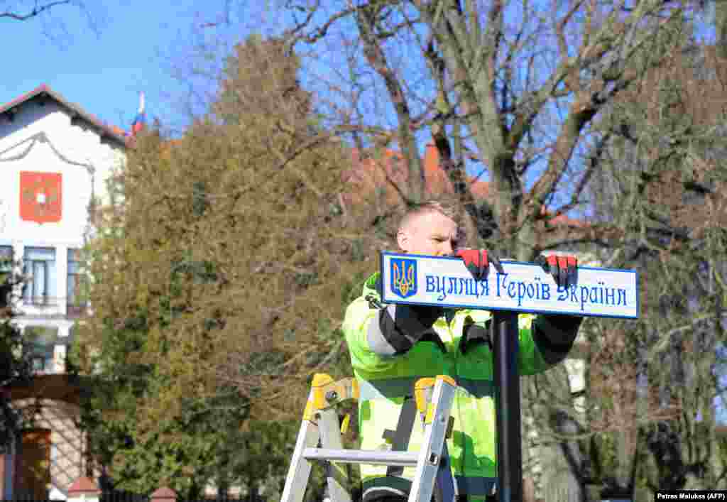 Martie 2022, Lituania - Un muncitor instalează un semn stradal pentru redenumirea unei străzi în „Strada Eroilor Ucrainei”. Drumul duce către ambasada rusă de la Vilnius.