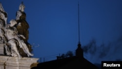 Fumul negru iese din coșul de pe acoperișul Capelei Sixtine. 