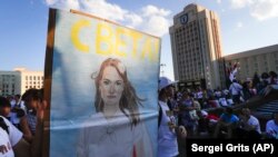 Луѓе носат портрет на Свјатлана Циханускаја, поранешен кандидат за претседателски избори, за време на митингот на опозицијата пред зградата на владата во Минск, 17 август 2020 година