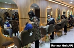 Cosmeticienele machiază clientele la un salon de înfrumusețare din Kabul, în aprilie 2021. Talibanii au închis acum toate saloanele de înfrumusețare.