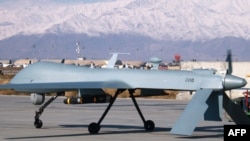 File photo of a drone armed with a missile setting off from its hangar at Bagram air base in Afghanistan.