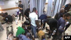 Palestinieni răniți la un punct de distribuire a ajutoarelor, la Khan Yunis, în sudul Fâșiei Gaza, așteaptă îngrijire la spitalul Nasser, pe 19 iulie 2025.