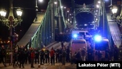 Rendőrök zárják le a Szabadság hidat a budai oldalon a gyülekezési jogról szóló törvény módosításának visszavonását követelő demonstrálók elől 2025. március 25-én