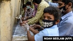 Učenici sa zaštitnim maskama peru ruke prije početka nastave u srednjoj školi koju vodi vlada u Secunderabadu, gradu blizancu Hyderabadu, Indija, mart 2020.