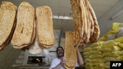 Egy iráni pék a hagyományos, barbari néven ismert kenyérrel a muzulmán szent hónap, a ramadán idején Teheránban 2016. június 22-én