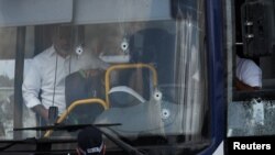 Găuri de gloanțe în parbrizul autobuzului în care a avut loc atacul.