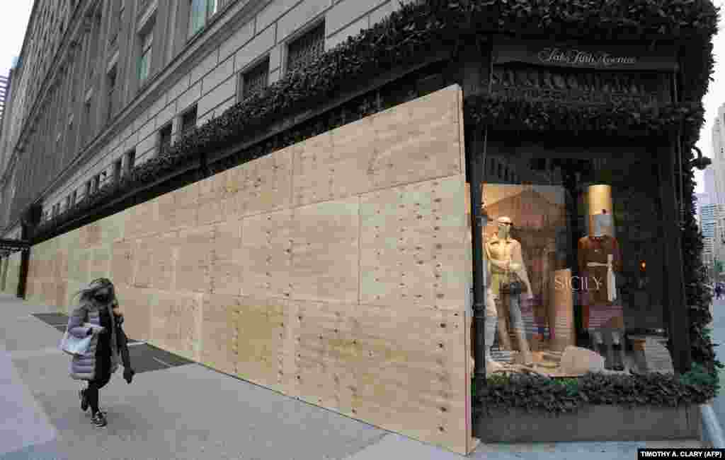 Жена шета покрај продавницата на Сакс на Петтата авенија во Њујорк.