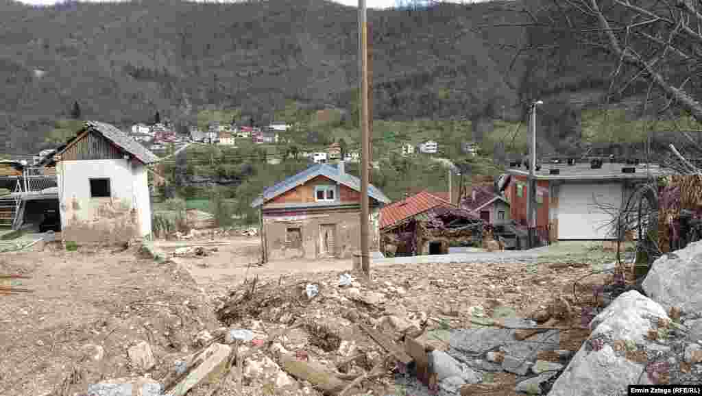 Pogled na donji dio naselja, gdje su kuće i objekti otkopani ispod kamenih nanosa. Kroz naselje su provedene vodovodne, kanalizacione i elektro instalacije sa uličnom rasvjetom. Prostupni putevi i kuće još čekaju na popravak.