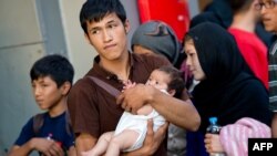 Семья мигрантов из Афганистана, прибывшая поездом из Будапешта, на вокзале Мюнхена. 31 августа 2015 года.