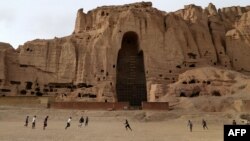 Афганские мальчики играют в футбол рядом со скалами, где стояли статуи Будды. Провинция Бамиан, февраль 2014 года.