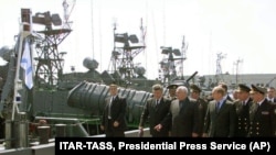 Vlagyimir Putyin orosz elnök a Kaszpi-tengeri Flotta hajói mellett sétál Asztrahán kikötőjében 2002. április 25-én