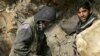 Miners drill into rock in a makeshift mine in northeastern Afghanistan (file photo).