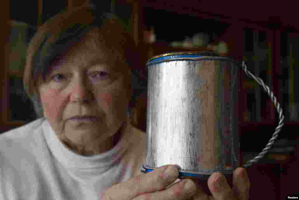 76-річна Зінаїда Тарасевич тримає саморобну кружку, якою її батьки довгі роки користувалися в таборі. Із більш ніж 20 родичів, відправлених у табір як політв’язні, її матері та батькові вдалося вижити і повернутися додому після смерті Сталіна